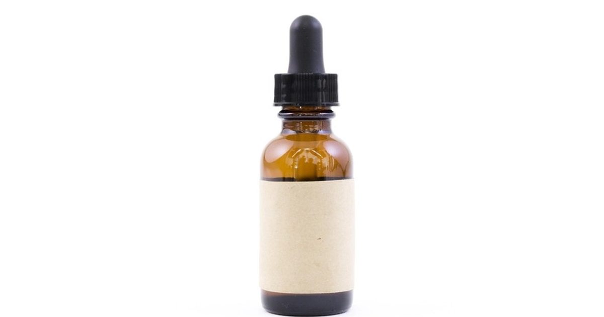 An amber glass dropper bottle with a blank label on a white background